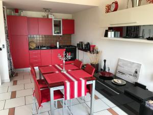 eine Küche mit roten Schränken und einem Tisch mit roten Stühlen in der Unterkunft Casa Svetlana in Stalettì