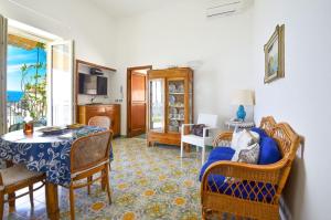 a living room with a table and chairs at AMORE RENTALS - Casa Raffi in Positano