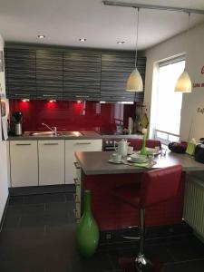 uma cozinha com paredes vermelhas e uma mesa com um vaso verde em Ferienhaus Finster em Volkach