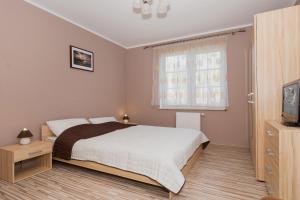 a bedroom with a large bed and a window at Apartamenty Villa Park by Renters in Świnoujście