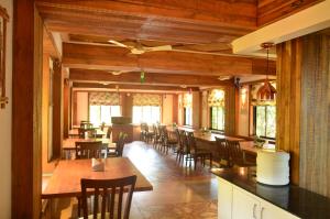 a dining room with wooden tables and chairs at Kaular Atithis Grand Kokan Resort in Ganpatipule