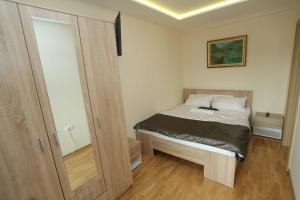 a small bedroom with a bed and a mirror at Apartment Kristal in Zlatibor