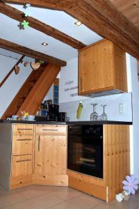 uma cozinha com armários de madeira e um forno preto em Ferienhaus Finster em Volkach