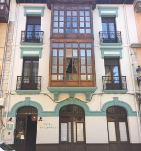 un bâtiment avec de nombreuses fenêtres sur son côté dans l'établissement Hotel Covadonga, à Ribadesella