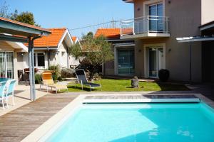 a swimming pool in the backyard of a house at Villa Marie Suzon - Belle propriété pour 16 personnes à 5 mn de la Hume in Gujan-Mestras