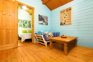 a room with blue walls and a table and a bed at Complejo Rural Huerta Grande in Algeciras