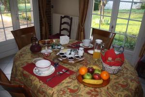 a table with a breakfast of fruit and juice at A la Volette in Pouillé