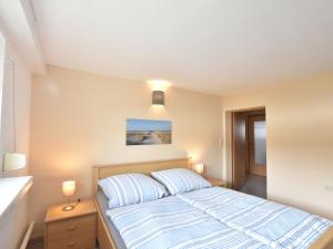 1 dormitorio con 1 cama con rayas azules y blancas en Charming Apartment in Rerik with Fenced Garden, en Rerik