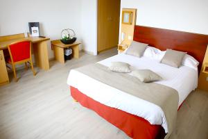 a bedroom with a large bed with a wooden headboard at Hôtel Restaurant Splendid Camargue in Le Grau-du-Roi