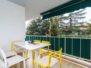 a balcony with a table and yellow chairs at Apartment Pical in Poreč