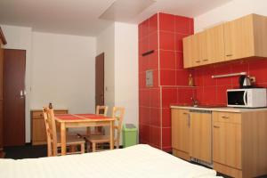 una pequeña cocina con mesa y microondas en Apartmány U Špirků, en Kvilda