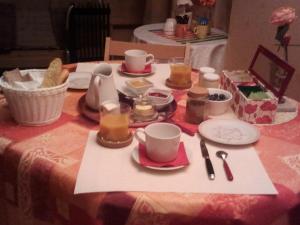 une table avec des tasses et des assiettes de nourriture dans l'établissement Pacéenne, à Pacé