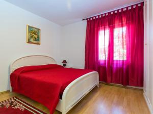 ein Schlafzimmer mit einem roten Bett und einem Fenster in der Unterkunft Apartment Nerina in Poreč