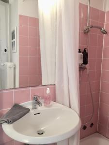 ein rosafarbenes Bad mit einem Waschbecken und einer Dusche in der Unterkunft Nice n' Nordic 4 in Hamburg
