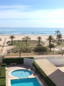 ガンディアにあるApartamento Las Sirenas, 1ª linea de playaのスイミングプールとビーチの景色を望めます。