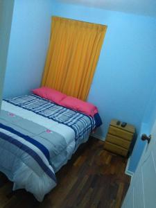 1 dormitorio con 1 cama con cortina amarilla en Mi casa es su casa, en Lima