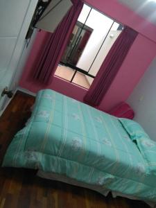 a bedroom with a bed in a room with a window at Mi casa es su casa in Lima