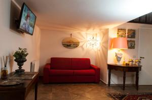 a living room with a red couch and a table at Camidù Boutique House in Palermo