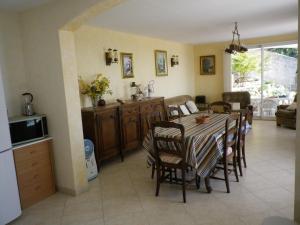 eine Küche und ein Esszimmer mit einem Tisch und Stühlen in der Unterkunft La Bastide Fleurie in Cavalaire-sur-Mer