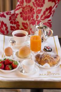 a breakfast tray with breakfast foods and coffee and fruit at Martius Private Suites in Rome