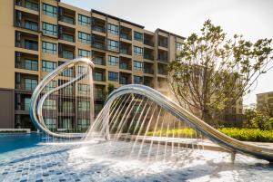 a water slide in a pool in front of a building at Rain cha-am by J in Cha Am