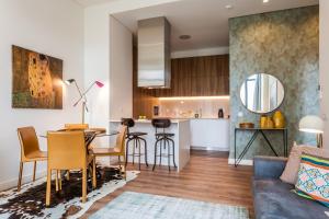 ein Wohnzimmer und eine Küche mit einem Sofa und einem Tisch in der Unterkunft Exclusive 1 bedroom flat in the heart of Lisboa in Lissabon