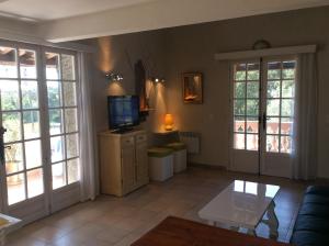 a living room with a couch and a tv at 89 Le Grand Pin in Sainte-Maxime