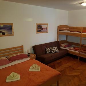 1 dormitorio con cama, sofá y literas en Guest House Čater en Laško