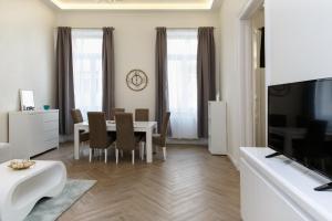 a living room with a dining room table and a television at Jenny luxury two bedrooms apartment. in Budapest