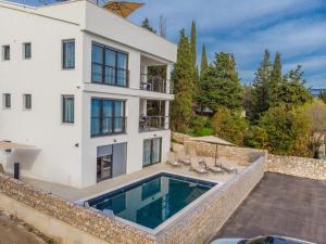 a large white house with a swimming pool at Apartment Di Blu in Novi Vinodolski