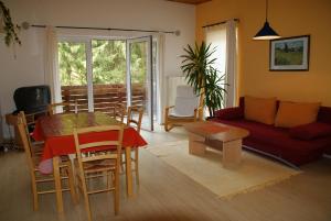 - un salon avec une table et un canapé rouge dans l'établissement Ferienhaus Bad Hundertpfund, à Grossbreitenbach