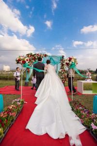 Eine Braut und ein Bräutigam, die bei einer Zeremonie den Gang entlang gehen. in der Unterkunft Onion Manor B&B歐尼恩莊園0549 in Altstadt von Hengchun