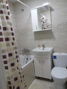 La salle de bains est pourvue de toilettes, d'un lavabo et d'une baignoire. dans l'établissement квартира-студия в центре, à Khmelnytsky