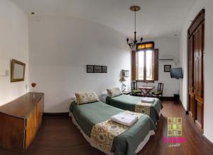 a room with two beds and a desk in it at A la Gurda in San Miguel de Tucumán