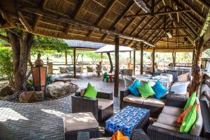 un patio en un complejo con sillas y mesas en Gabbata Lodge, en Leeuwfontein
