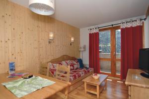 - un salon avec un canapé et une table dans l'établissement Résidence Odalys Le Grand Panorama 1, à Valmeinier
