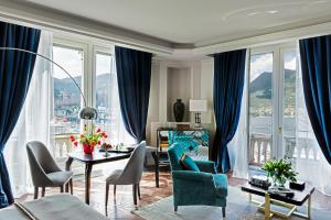 a living room with blue curtains and a table and chairs at Vista Palazzo - Small Luxury Hotels of the World in Como