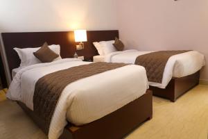 Postel nebo postele na pokoji v ubytování Visthara inn - Comfort Stay