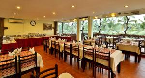 a dining room with tables and chairs in a restaurant at Kalathil Lake Resort in Vaikom