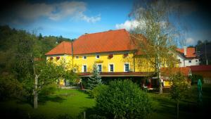 ein großes gelbes Haus mit rotem Dach in der Unterkunft Guest House Čater in Laško