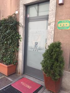 una puerta delantera de un edificio con dos macetas en Hotel Il Loggiato Dei Serviti, en Como