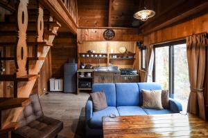 un soggiorno con divano blu in una cabina di The Hut a Hakuba