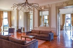 een woonkamer met 2 banken en een kroonluchter bij Château Grattequina Hôtel in Blanquefort