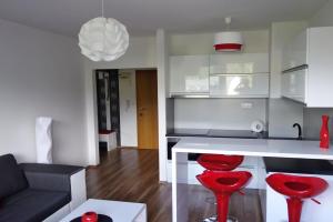uma cozinha e sala de estar com cadeiras vermelhas e uma mesa em Apartman "21" em Tatranska Strba