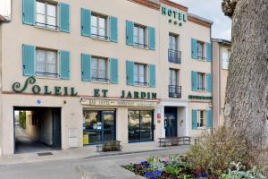 un bâtiment avec volets bleus dans une rue dans l'établissement Soleil et Jardin, à Solaize