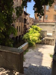 Une allée avec des bâtiments et une rue avec de l'eau dans l'établissement Palazzo Guerrieri da Fermo, à Mantoue