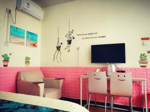 延庆县Beijing Badaling Great Wall Caos Courtyard Hostel 1VIP service 2Ancient style Chinese yard 3 only 15 minutes walk to the Badaling Great Wall 4 be your free advisor 5 offer private guided tour 6 experience local food and culutre的有一张桌子、两把椅子和一台电视的房间