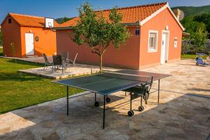 a ping pong table in front of a house at Vacation house Radosic in Radošić
