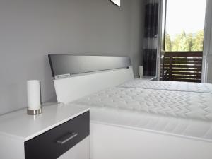 uma cama branca num quarto com uma janela em Apartman "21" em Tatranska Strba