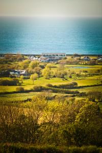 a view of a field with the ocean in the background at Waves Guest Suites in Castel